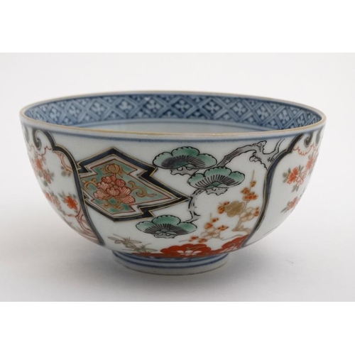 426 - A Japanese ceramic bowl having floral decoration including flowering cherry blossom boughs in Imari ... 