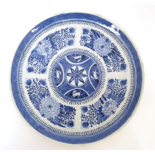 428 - An Chinese blue and white plate decorated with panels of Chrysanthemums and other stylised flowers a... 