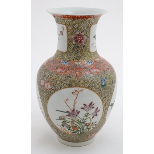 429 - A Chinese famille rose ovoid vase, the cartouches decorated with flowering boughs and birds having g... 