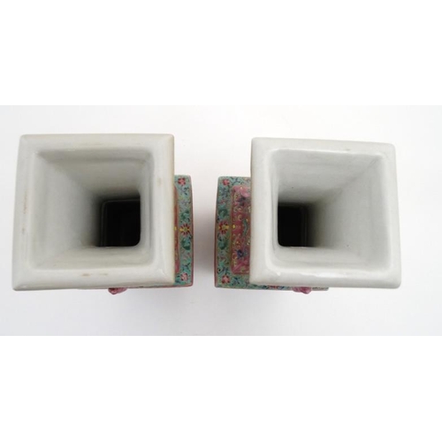 430 - A pair of Chinese twin handled square form vases with flared rims decorated in polychrome enamels wi... 