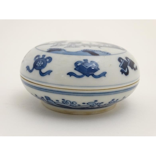 438 - A Chinese blue and white circular ink pot and cover, decorated with female figures in a garden scene... 