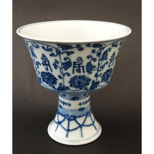 444 - A Chinese blue and white stem cup , the outside decorated with stylised chrysanthemums and character... 