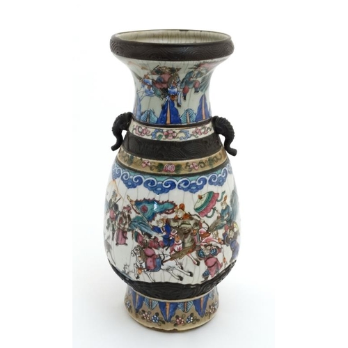 453 - A large Chinese crackle glazed two handled vase decorated with warring figures on horseback under st... 