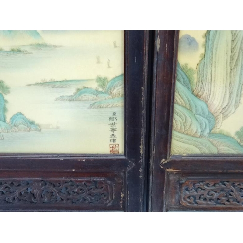 454 - A large pair of Chinese ceramic panels in wooden frames, each having two panels decorated with river... 