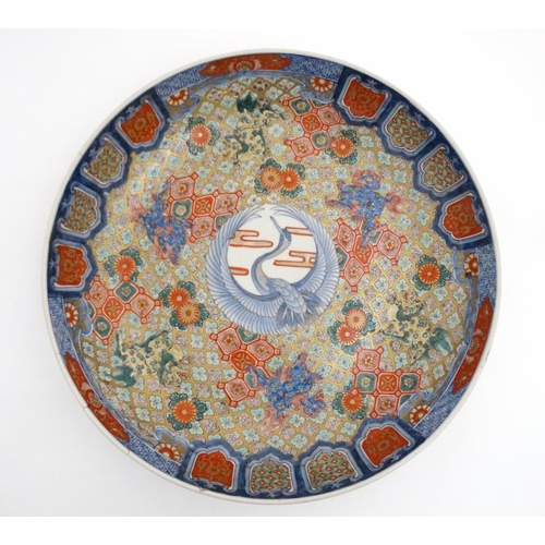 457 - A Large Chinese bowl decorated in Imari style colours on a white ground, decorated with dogs of fo a... 