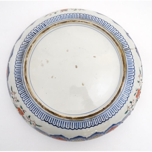 457 - A Large Chinese bowl decorated in Imari style colours on a white ground, decorated with dogs of fo a... 