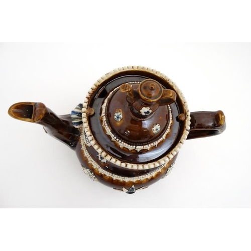 478 - A 19thC large Bargeware / Measham teapot decorated with traditional design on a brown glazed body, h... 