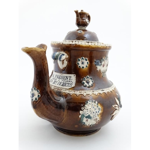 478 - A 19thC large Bargeware / Measham teapot decorated with traditional design on a brown glazed body, h... 