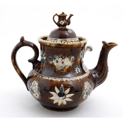 478 - A 19thC large Bargeware / Measham teapot decorated with traditional design on a brown glazed body, h... 