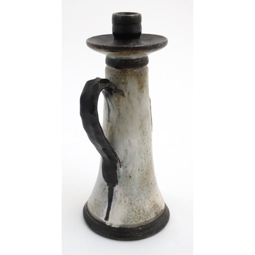 503 - A Continental studio pottery Tavern tall handled candle stick, having brown shield to front depictin... 