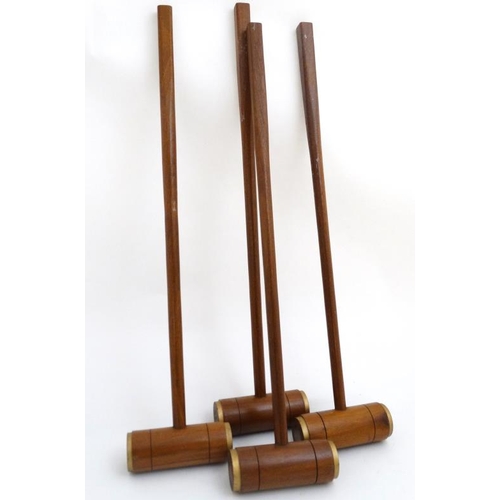 118 - A set of 4 20thC wooden croquet mallets, having gilt painted bands to edges. 40'' high. (4)