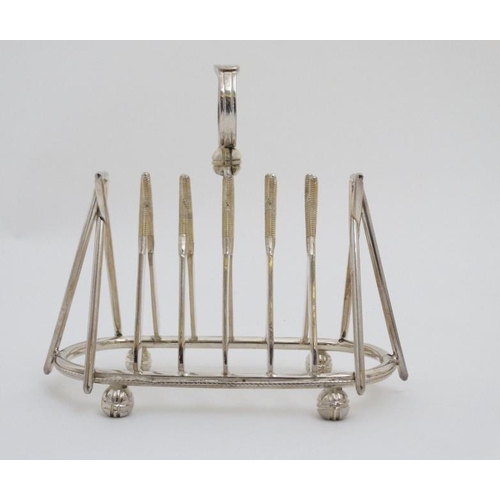 122 - A novelty 6-slice silver plated toast rack, the bars formed as crossed cricket bats.  21stC  . Appro... 