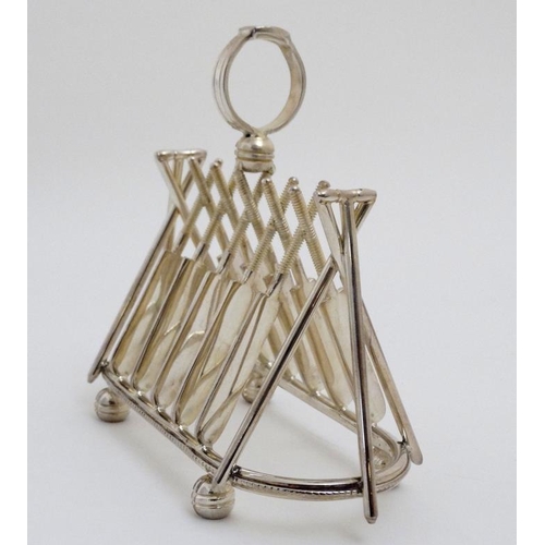 122 - A novelty 6-slice silver plated toast rack, the bars formed as crossed cricket bats.  21stC  . Appro... 