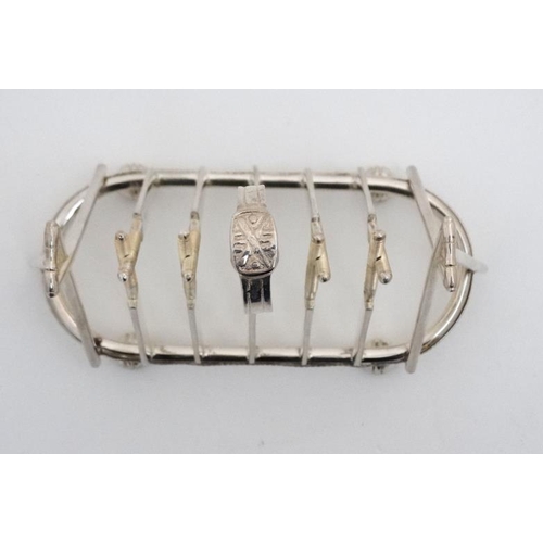 122 - A novelty 6-slice silver plated toast rack, the bars formed as crossed cricket bats.  21stC  . Appro... 