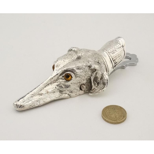 213 - A silver plate desk top letter clip in the form of a dogs head. 21stC.  5'' long