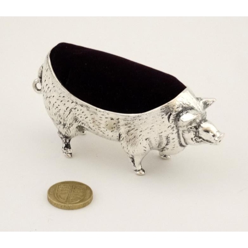 219 - A white metal pin cushion formed as a pig. 21stC. Approx 4'' long