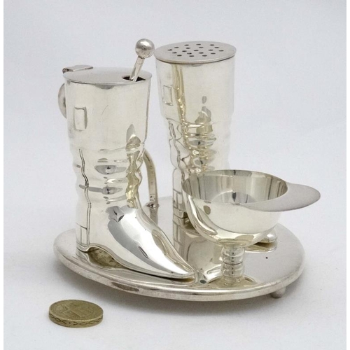 222 - A novelty silver plate cruet comprising pepper and mustard pots formed as riding boots and the salt ... 