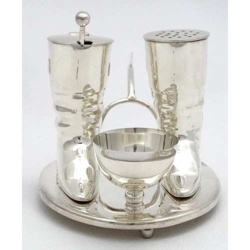 222 - A novelty silver plate cruet comprising pepper and mustard pots formed as riding boots and the salt ... 