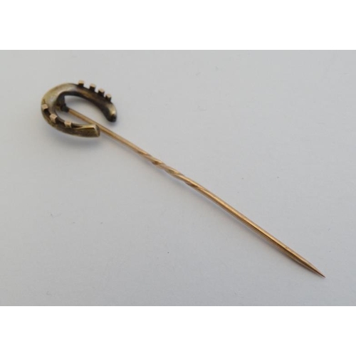 234 - Horse Riding Interest: A gilt metal stick pin surmounted by a horseshoe