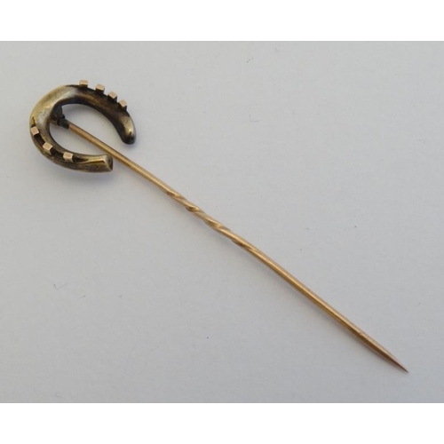 234 - Horse Riding Interest: A gilt metal stick pin surmounted by a horseshoe