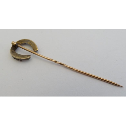 234 - Horse Riding Interest: A gilt metal stick pin surmounted by a horseshoe