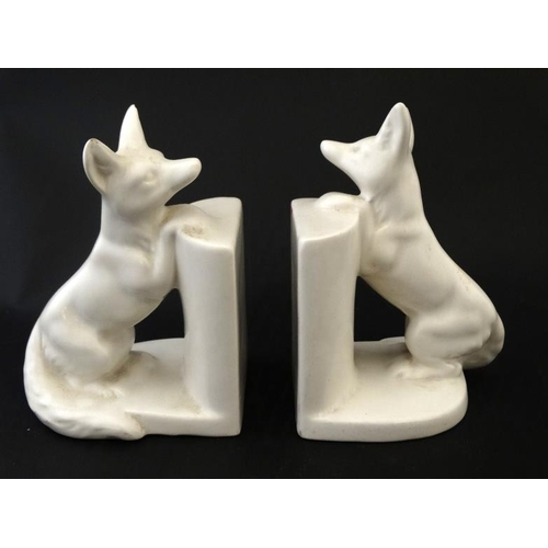 275 - Ceramic Bookends : a pair of continental white glaze bookends formed as foxes peering over a wall , ... 