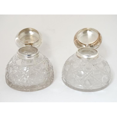 284 - Two cut glass inkwells having silver plated hinged tops with later applied cabochons depicting dogs ... 