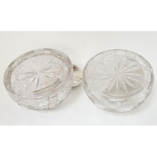 284 - Two cut glass inkwells having silver plated hinged tops with later applied cabochons depicting dogs ... 