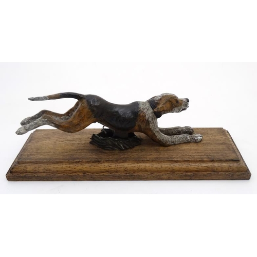 68 - A hunting paper clip in the form of a 21stC cold painted cast bronze hound on oak base. The base 11'... 