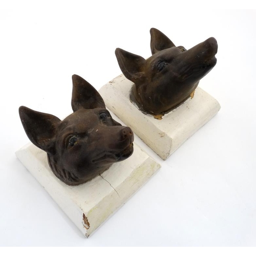 69 - A pair of 19thC cast iron stylised fox masks on squared plinths. For external use 8'' deep x 6 3/4''... 