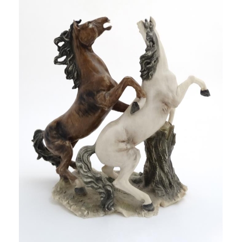 76 - A modern resin polychrome sculpture of two rearing horses , signed B Auzot. 15'' high.