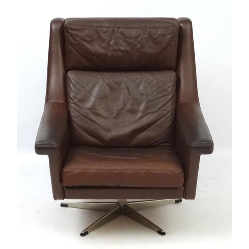 148 - Vintage Retro :A Danish brown leather swivel and tilt armchair  supported on a 5 spoke chromed base,... 