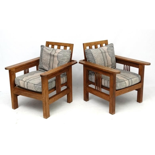 203 - Arts and Crafts : a pair of early 20thC oak armchairs with adjustable rake back , arm rests and side... 