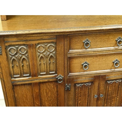 214 - An oak sideboard with carved and linen fold decoration together with a matching corner cupboard and ... 