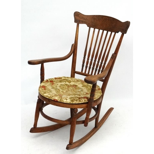 217 - An American oak and bentwood circular seated rocking chair with open arms. 34 1/2'' high