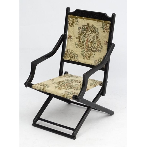 218 - A late 19thC ebonised folding open armchair 33'' high