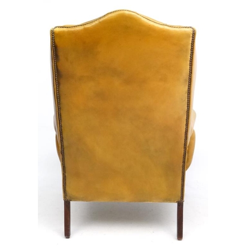 247 - A late 20thC Georgian style light tan leather button back wing arm chair 47'' high