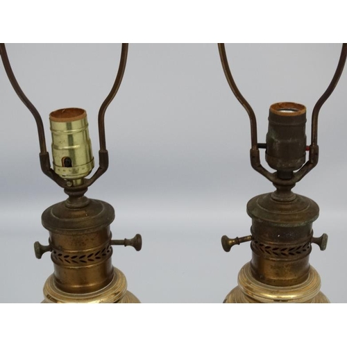 251 - A pair of early 20thC oil lamp conversions now formed as electric table lamps with gilded brass and ... 