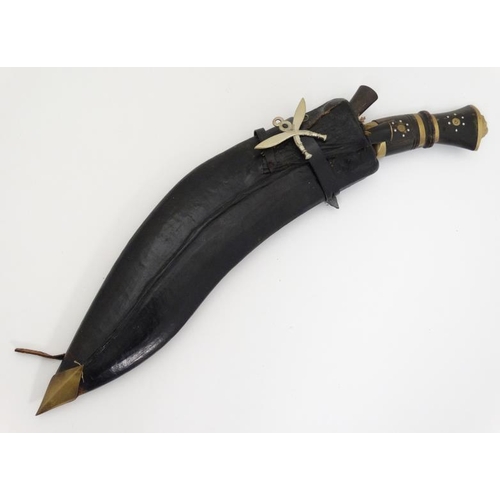 328 - Militaria : An mid 20thC Nepalese / Indian Kukri knife , 11 1/2'' blade with a 4'' brass and hardwoo... 