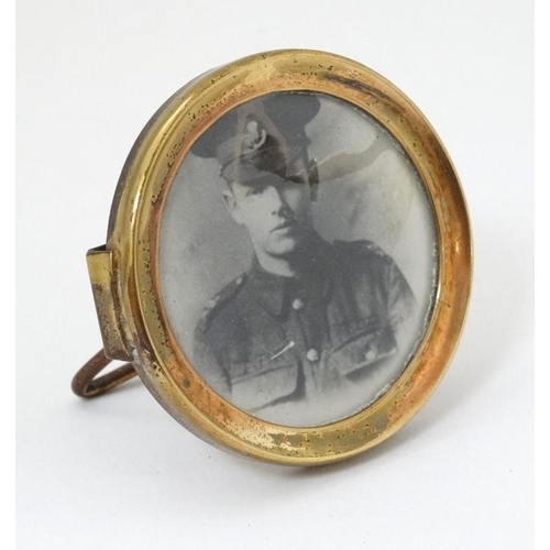 337 - Militaria : A small Trench Art brass circular Strut Frame , with uniform portrait photograph of a yo... 