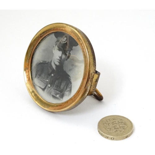 337 - Militaria : A small Trench Art brass circular Strut Frame , with uniform portrait photograph of a yo... 