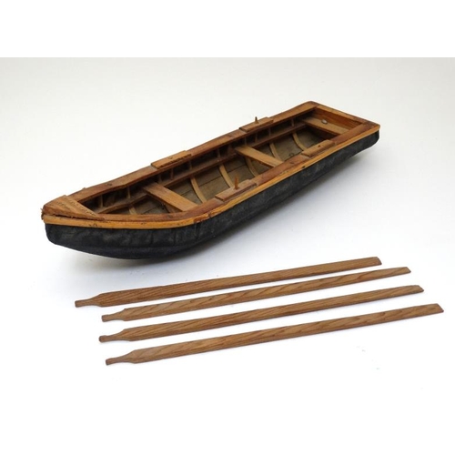 383 - Toy: A small hand made wooden toy boat with 4 oars, the hull formed with stretched fabric, bears Gal... 