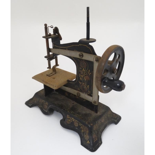 385 - Toy: A c1900 German Hand crank child's / miniature metal sewing machine, having floral decoration on... 