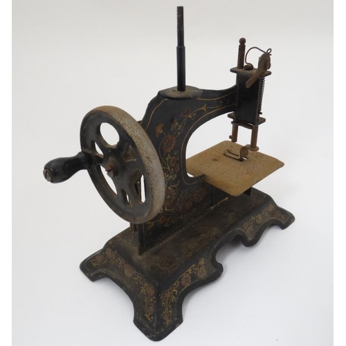 385 - Toy: A c1900 German Hand crank child's / miniature metal sewing machine, having floral decoration on... 