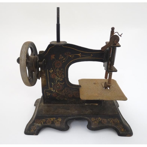 385 - Toy: A c1900 German Hand crank child's / miniature metal sewing machine, having floral decoration on... 