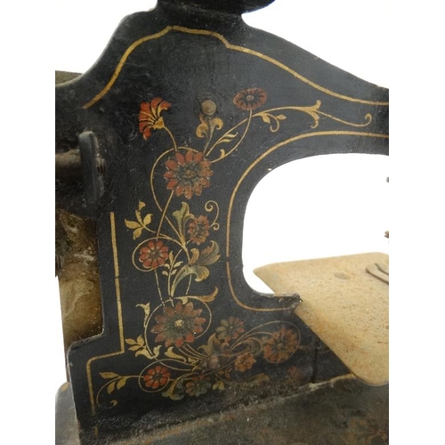 385 - Toy: A c1900 German Hand crank child's / miniature metal sewing machine, having floral decoration on... 