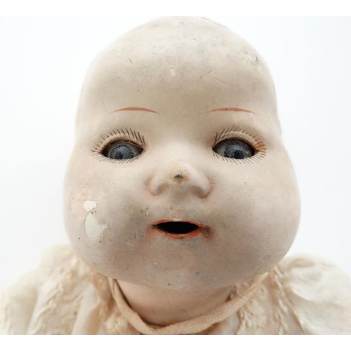 387 - Toy: A German Bisque Childs doll, having blue glass painted eyes , painted features and hinged limbs... 