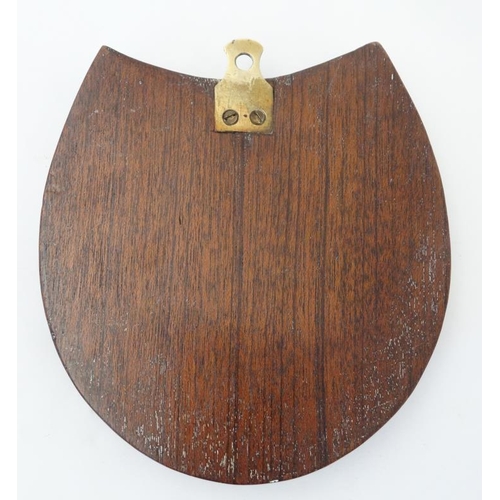 390 - A medium brass cribbage board formed as a horseshoe, with four pegs and mounted upon a wooden plinth... 