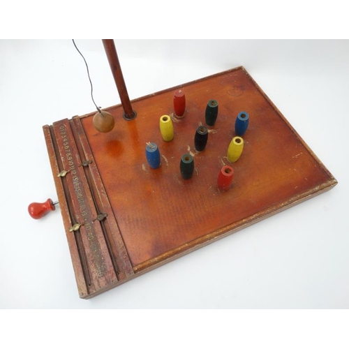 396 - Toys: A mid 20thC wooden table skittles board with integral score board and gilt coloured numbers to... 