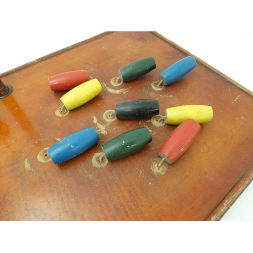 396 - Toys: A mid 20thC wooden table skittles board with integral score board and gilt coloured numbers to... 